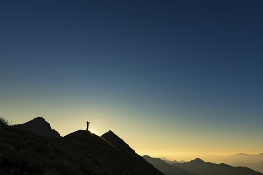 Mountaineer on summit ridge with backlight, in the background Ammergau Alps, Reutte, Ammergau Alps, Tyrol, Austria