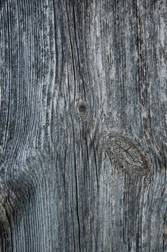 Close-up of aged weathered wooden planks with cracked, peeling, and rough natural grain. Gray and brown tones create a rustic, distressed surface texture suitable for backgrounds, vintage designs, con