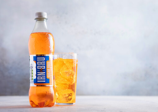 LONDON,UK - MARCH 25, 2026: Bottle of Irn Bru Sugar Free soft soda drink with glass of cold drink on light table background.