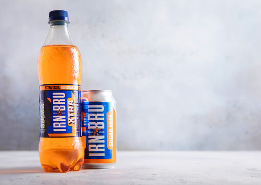 LONDON,UK - APRIL 09, 2026: Bottle of and aluminium can of Irn Bru soft soda drink on light table background.