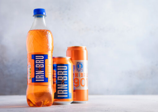 LONDON,UK - MARCH 19, 2026: Original Bottle of and aluminium cans of Irn Bru soft soda drink on light table background.