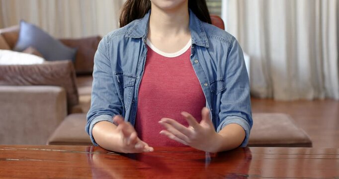 Close up of people talking to the camera, gesturing with hands, woman in casual attire sitting at ta