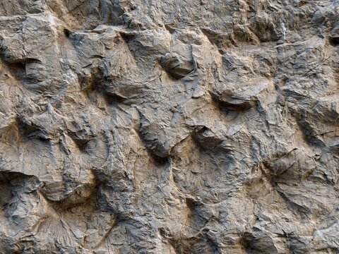 Rough rock wall surface showing natural textured pattern, strong geological formation, and weathered stone detail for background design in balearic islands, spain