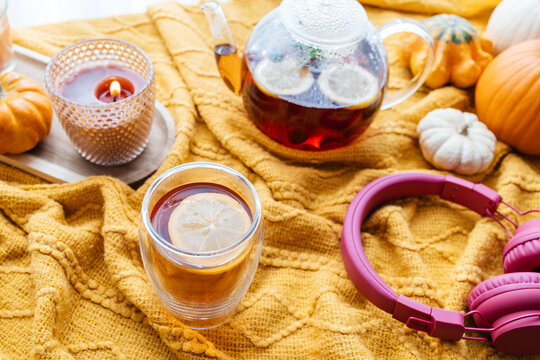 Autumn tea time with headphones and pumpkins enjoying hygge