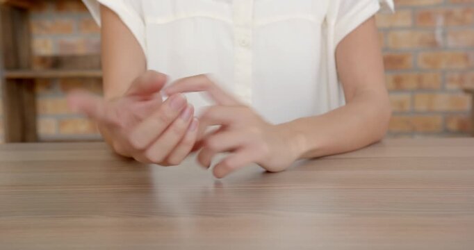 Close up of people talking to the camera, gesturing with hands, person sitting at wooden table in bu