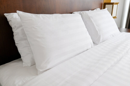 Clean white stripe hotel bed sheets and pillows