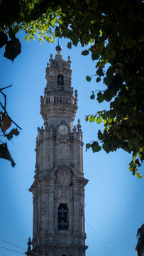 View of the Cl&eacute;rigos Tower or Torre dos Cl&eacute;rigos in between trees, in the city of Porto, Portugal