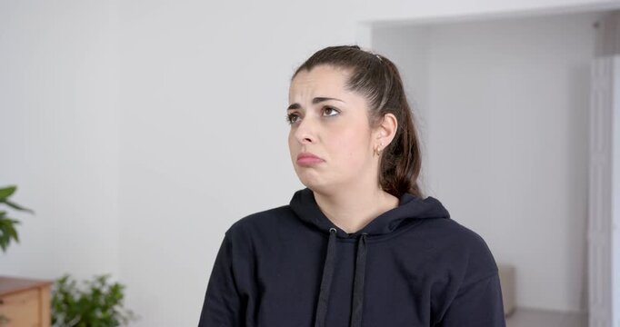 High speed photography for dynamic scenes, woman in black hoodie pouting, expressing sadness or disa