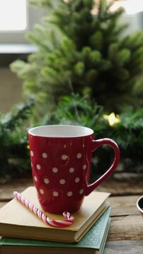 Vertical video. Cup of steaming hot drink against festive Christmas interior. Warm cozy winter atmosphere.