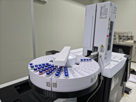 Automated gas chromatography laboratory instrument with rotary autosampler and sample vials for chemical analysis, quality control, forensic testing, and scientific research