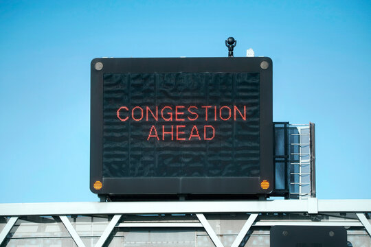 Motorway gantry Congestion Ahead sign aganst the blue sky
