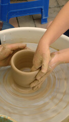 Hands shaping wet clay on a spinning pottery wheel © bboggi