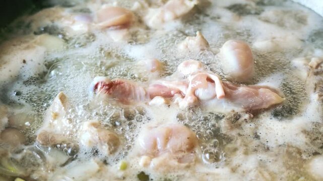 Slow Motion of Raw Chicken Pieces Boiling in Hot Water Pot with White Foam
