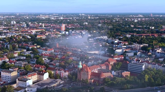 Smoke column rising over Berlin buildings, indicating a significant fire incident and potential infrastructure impact. Dramatic aerial view top-down drone