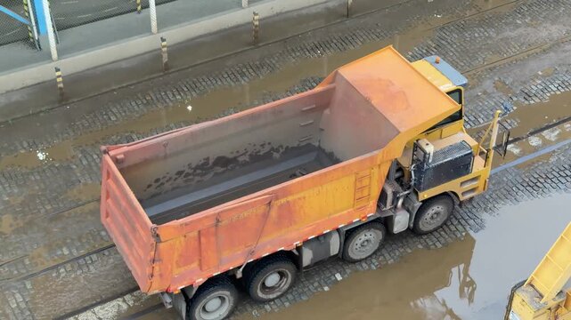 heavy dumping truck proceeding by port wharf.