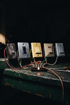 Moody vintage switch panel with tangled wiring and warm glow