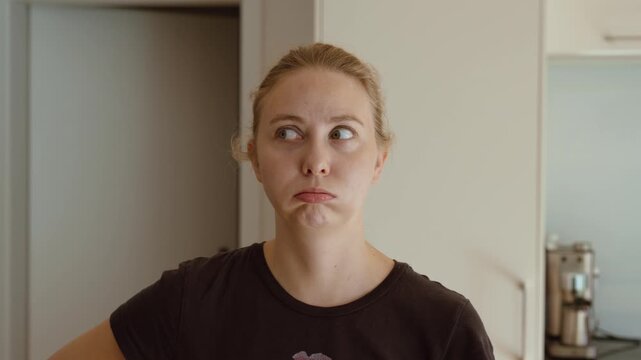 Woman rolling her eyes and making an annoyed facial expression, showing frustration, irritation and impatience.