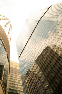Reflective glass office towers in Warsaw Poland forming a bright urban canyon with geometric facades and modern business architecture