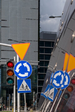 Traffic signs and signals reflected between modern buildings in Warsaw Poland creating a layered urban composition with street infrastructure