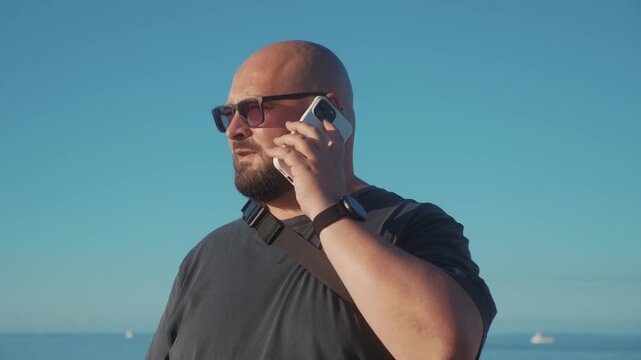 Man searching for mobile reception after dropped call, raising smartphone and checking screen as weak signal disrupts network connection by sea.