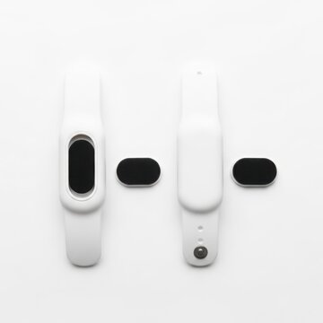 White Fitness Tracker Wristbands With Detachable Black Sensor Modules On White Background