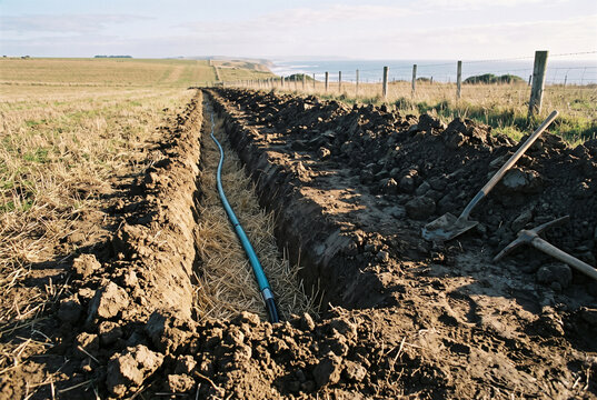 Irrigation Trench and Pipe Installation in Rural Field Earthworks