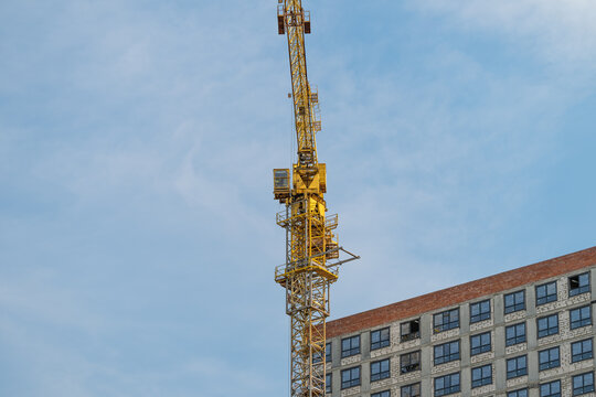 Construction crane reaching high into a clear blue sky in an urban setting