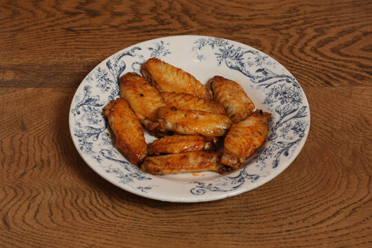 Poulet r&ocirc;ti sur une assiette d&eacute;cor&eacute;e avec des ailes de poulet cuites