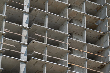 Construction progress of a tall building with concrete structure on a clear sunny day © beholdereye