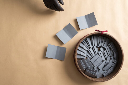 Raffle draw with folded paper slips in a bowl