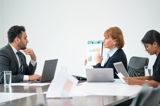 Three professionals collaborate in a bright meeting room