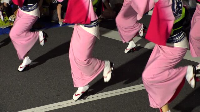 TOKYO, JAPAN - AUG 2026 : Slow motion shot of Awa Odori dance festival in Koenji. Powerful and energetic dance and music. Traditional Japanese summer event in Tokyo. Close up shot of lady dance step.