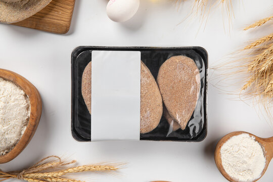Raw breaded meat patties cutlets packed in plastic tray with blank label mockup on white background