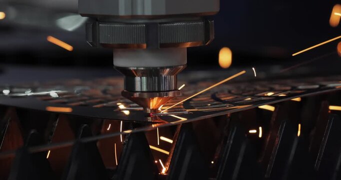 Industrial CNC laser cutting machine with flying sparks in metal fabrication.