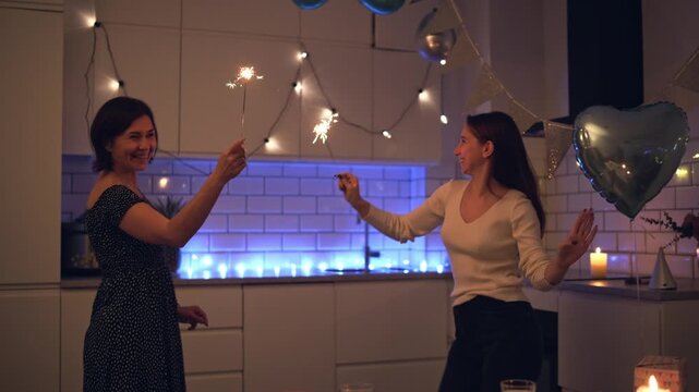 Cheerful Family Dances Together During A Home Birthday Party While Waving Glowing Sparklers