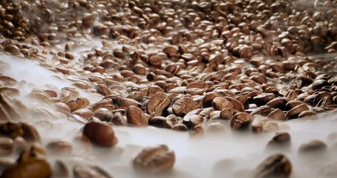 Steaming roasted coffee beans background with selective focus.