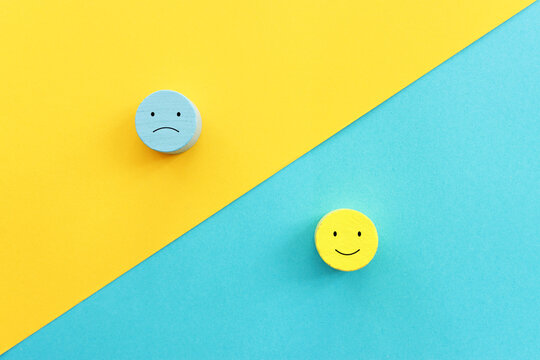 Top view image of wooden cubes with of happy and sad face. concept of happiness emotion and satisfaction