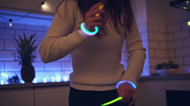 Young Girl Dancing At Home With Bright Glowing Neon Bracelets On Wrists