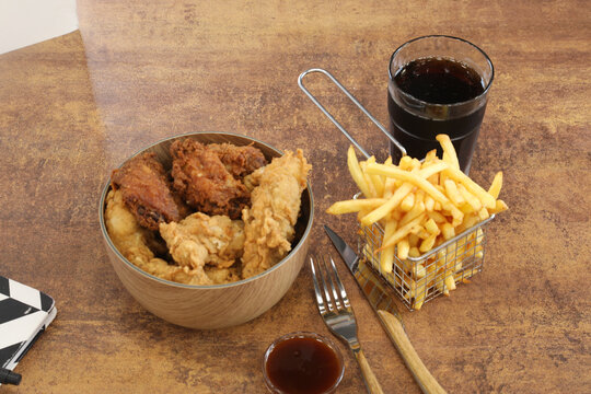 Repas rapide avec poulet frit, frites et boisson gazeuse dans un restaurant