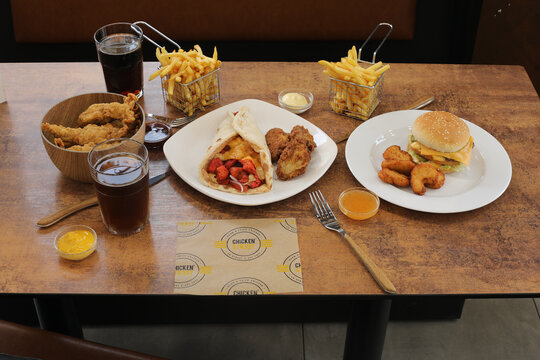 Repas de fast food sur une table avec boissons et plats vari&eacute;s