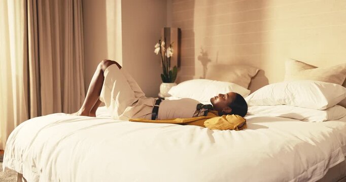 Hotel room, woman and relax on bed for travel fatigue, hospitality comfort and unwind on holiday. Cozy, tired guest and resting at lodge for post check in, vacation downtime and decompress with jump