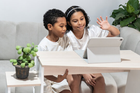 Children doing a video call on a tablet at home