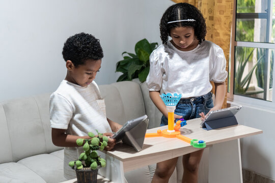 Black children using digital tablets and playing indoors