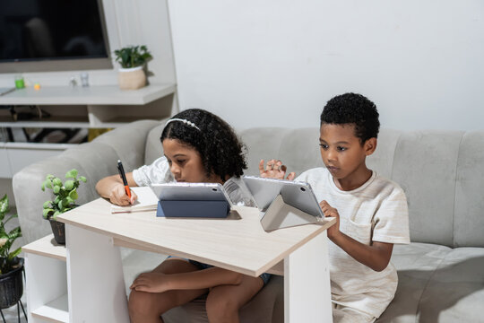Children learning online with tablets at home