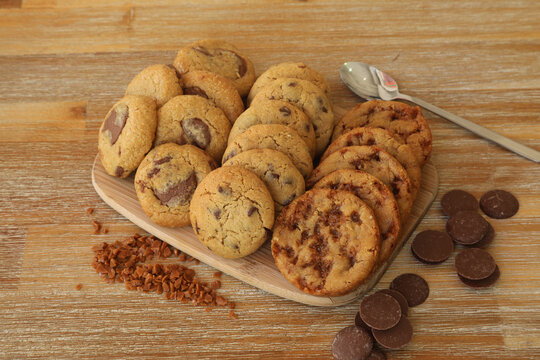 G&acirc;teaux et biscuits dispos&eacute;s sur une planche en bois avec des morceaux de chocolat