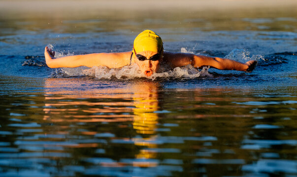 White swimmer performing butterfly stroke in open water