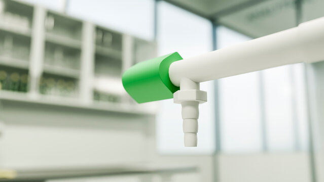 Green valve attached to white pipe fixture in laboratory