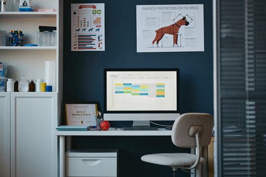 Empty veterinary clinic office with desktop computer displaying appointment schedule on screen. Suitable for pet healthcare management and animal clinic software marketing