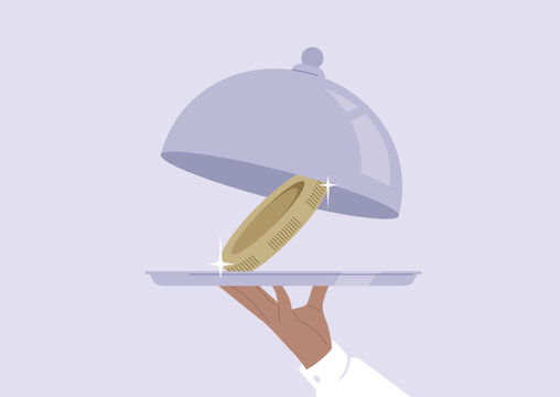 A waiter opening a metal cloche revealing a big metal coin on a tray