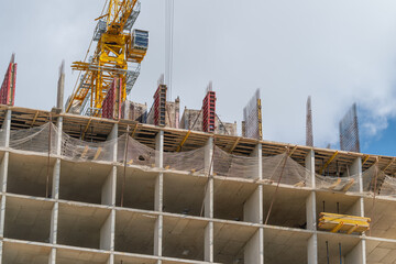 Construction site bustling with activity as workers diligently build a high-rise structure under a vivid blue sky © beholdereye